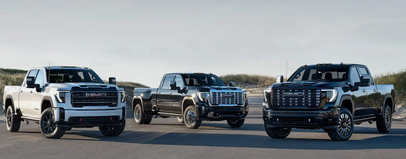 A lineup of three 2026 GMC Sierra HD trucks parked near each other.