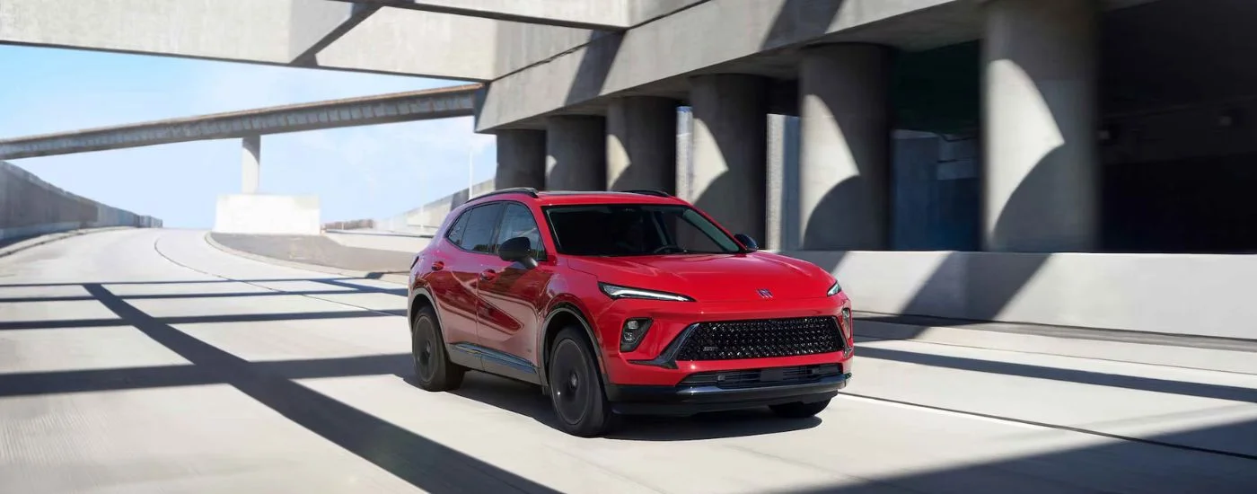 A red 2026 Buick Envision shown driving on a paved road.