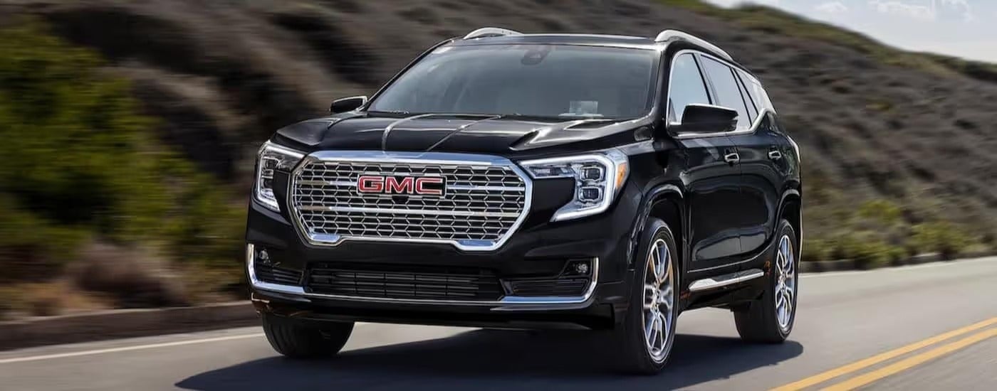 Black 2024 GMC Terrain driving down an open road