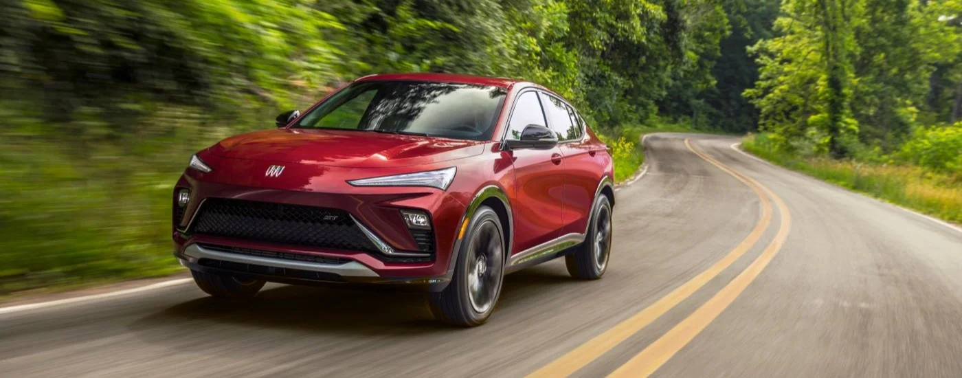 Red 2025 Buick Envista ST driving down an open road.