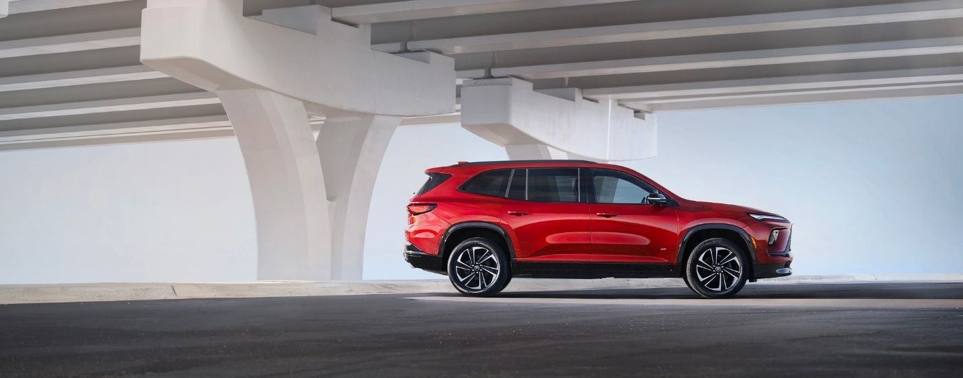 A red 2026 Buick Enclave from the side after leaving a Buick dealer.