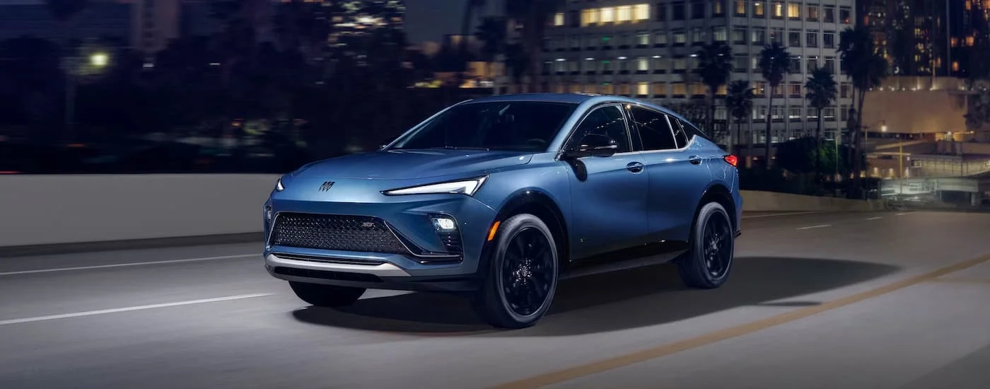Blue 2026 Buick Envista driving down an open road.