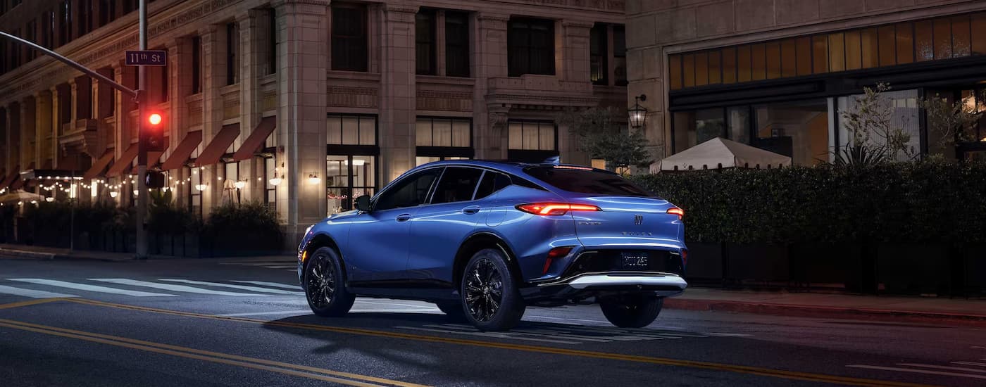 A blue 2026 Buick Envista parked in a city at night