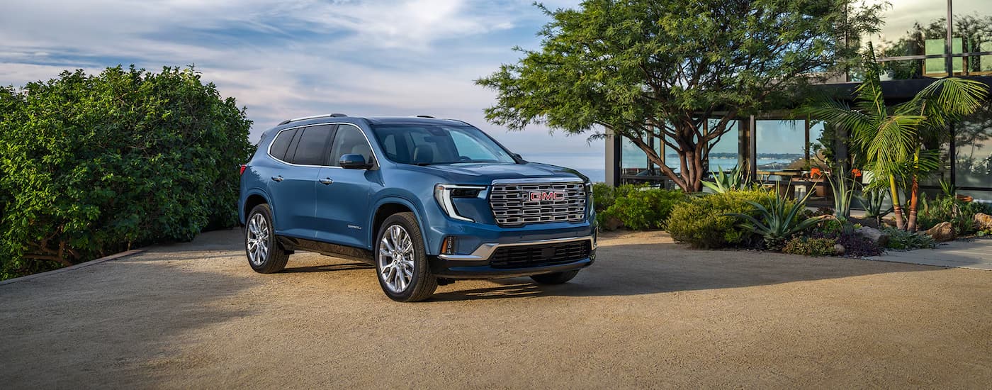 Blue 2026 GMC Acadia parked near trees