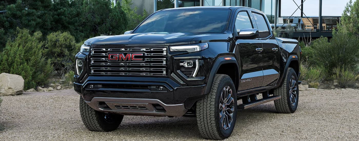 Black 2026 GMC Canyon parked on gravel near a GMC dealer