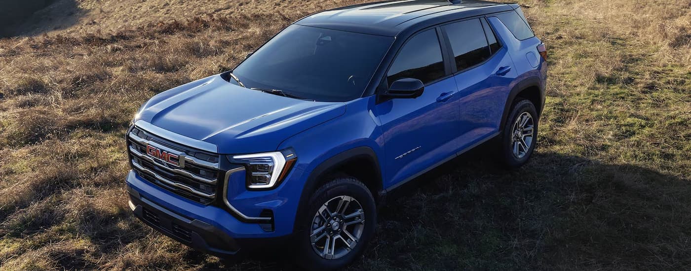 Blue 2026 GMC Terrain parked in an open field