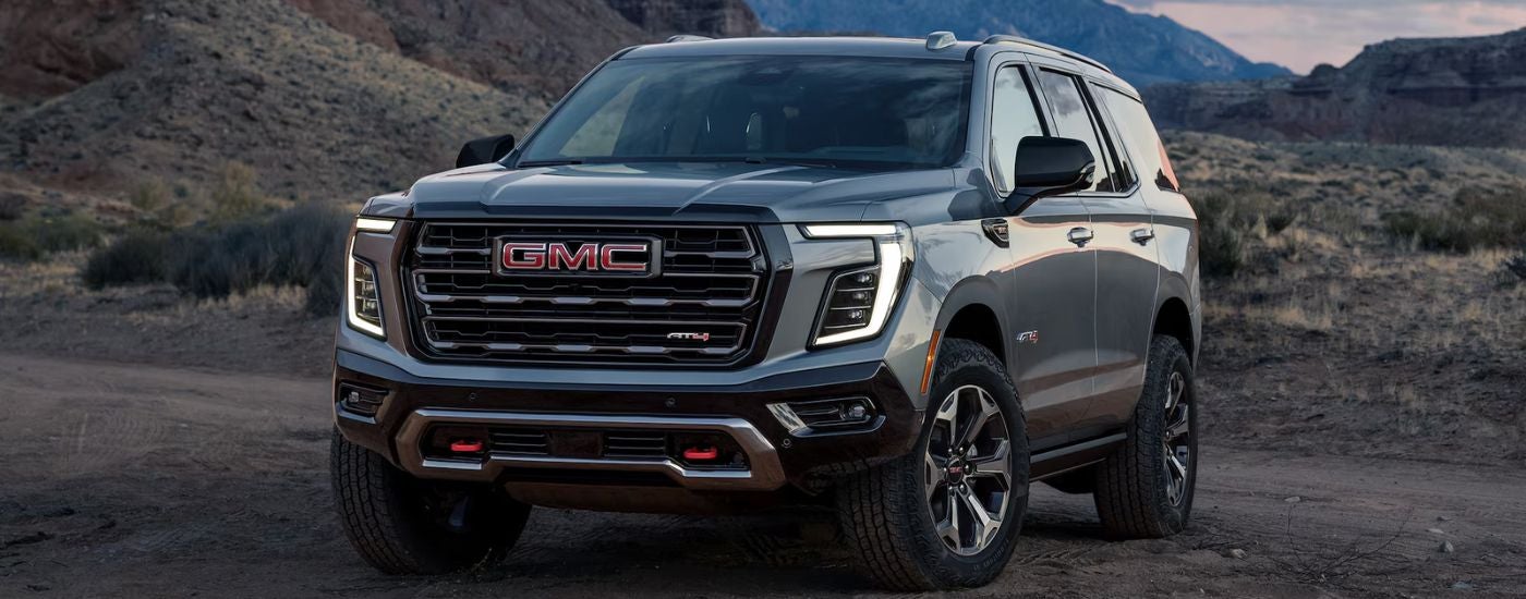 Grey 2026 Yukon AT4 off-road in a desert.
