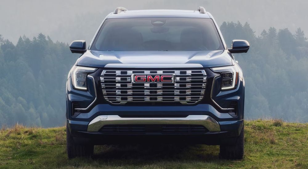 Blue 2027 GMC Terrain front view in a grassy field.
