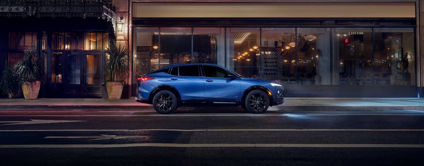 A blue 2026 Buick Envista driving in a city at night.