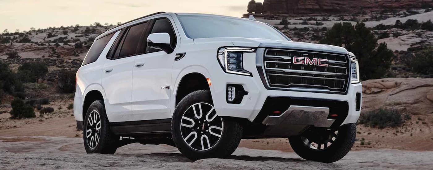 A white 2022 GMC Yukon parked on rocky terrain.