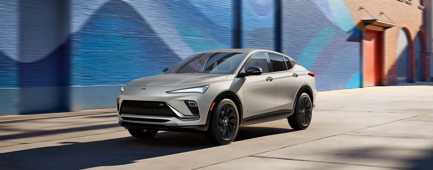 Silver 2026 Buick Envista driving near a blue wall mural