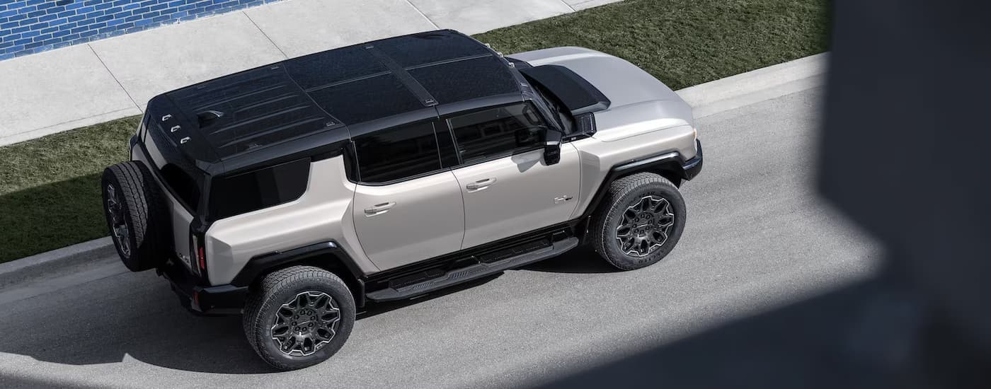 A silver 2026 GMC Hummer EV SUV parked in a city.