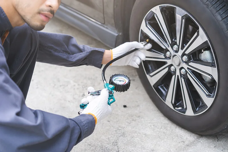 A technition inspecting a tire pressure